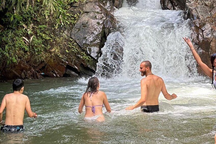 Persone in un ambiente naturale con una cascata. 4