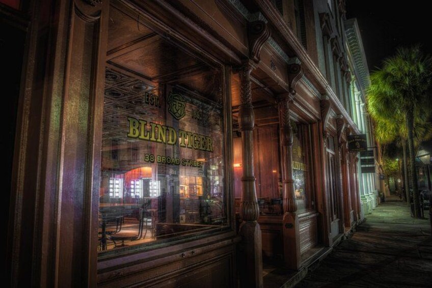 A building with ornate wooden details and a sign that reads 'BLIND TIGER.' 2