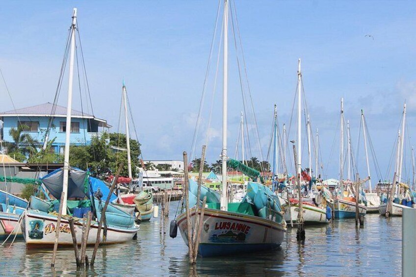 Un puerto deportivo con varias embarcaciones amarradas, un edificio al fondo y agua tranquila. 2
