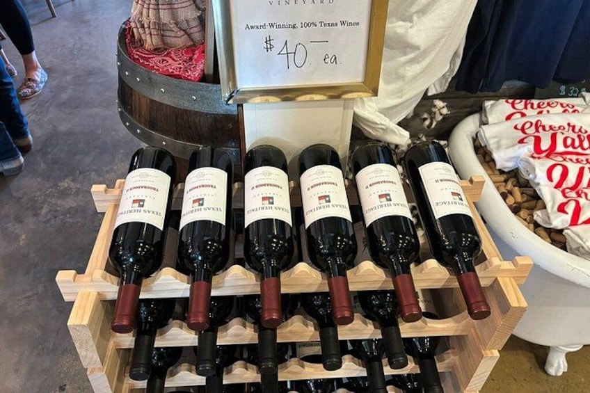 A display of wine bottles on wooden racks with a sign indicating a price of $40 per case. 2