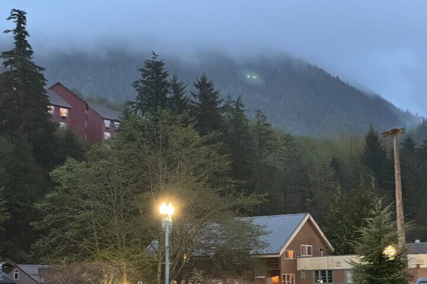 A foggy mountain with a red building and a street lamp. 2