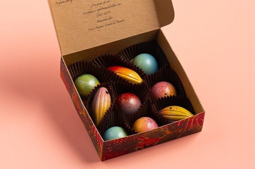 Une boîte de chocolats aux couleurs vives et aux motifs variés, avec un décor rouge et noir. 4