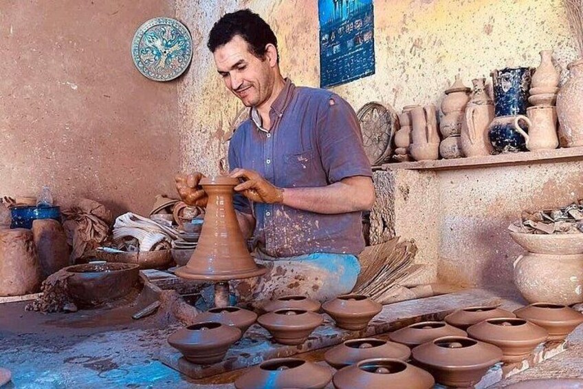 Una persona moldeando un recipiente de arcilla en un torno alfarero. 3