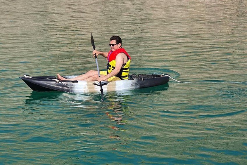 Eine Person sitzt in einem Kajak auf ruhigem Wasser. 3
