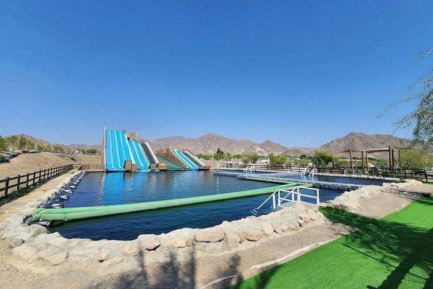 Ein Wasserpark mit zwei blauen Rutschen und einem Schwimmbecken. 4