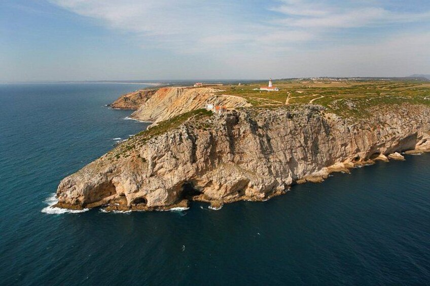 Une falaise côtière surmontée d’un phare, un paysage accidenté et une vue dégagée sur la mer. 3