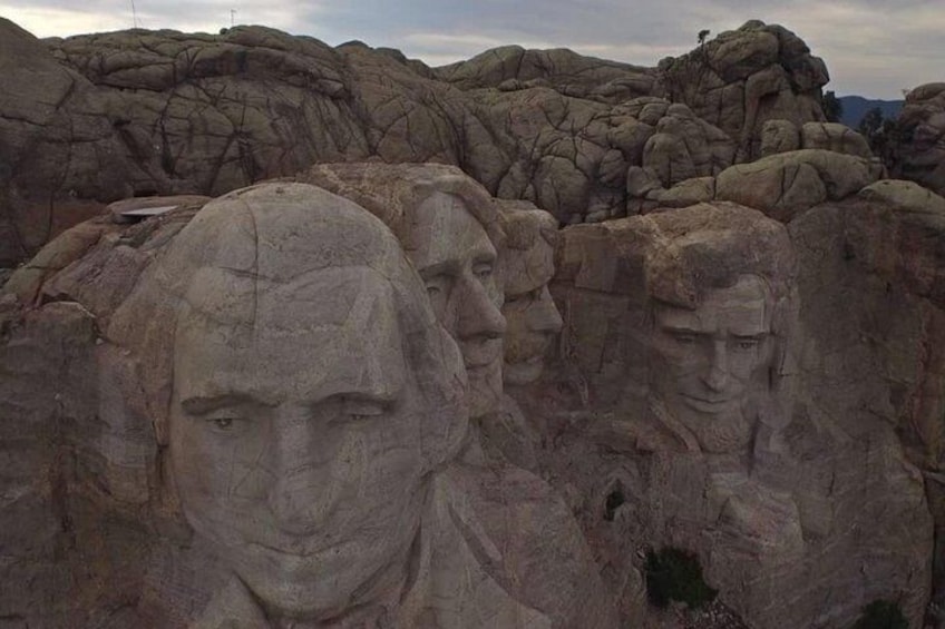 A series of large rock formations with carved faces. 2