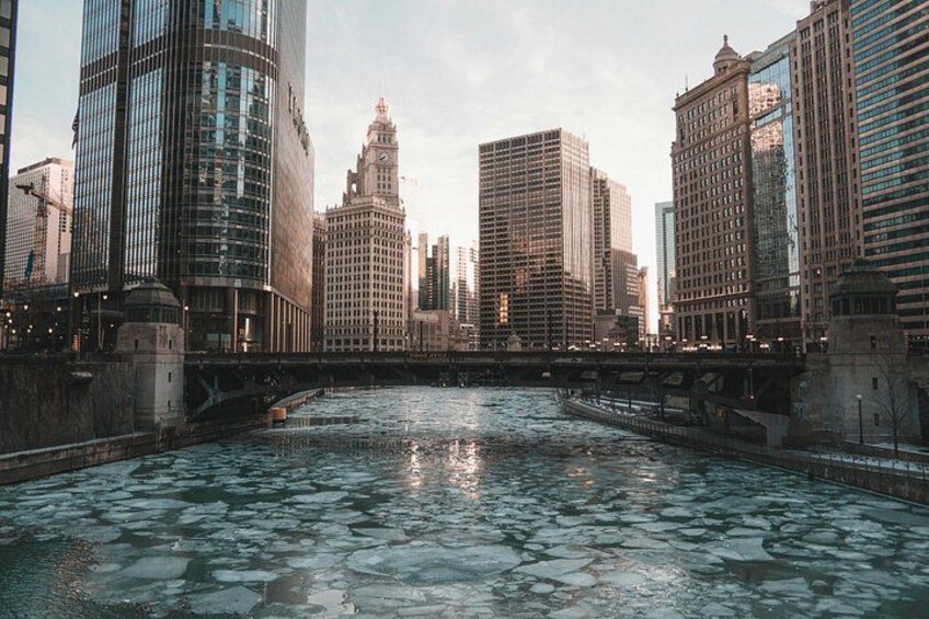 A river with ice floes, surrounded by modern skyscrapers and a historic building with a clock tower. 5