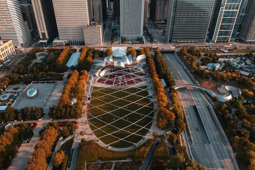 An aerial view of a cityscape with modern buildings, a central plaza with a geometric pattern, and surrounding greenery. 4