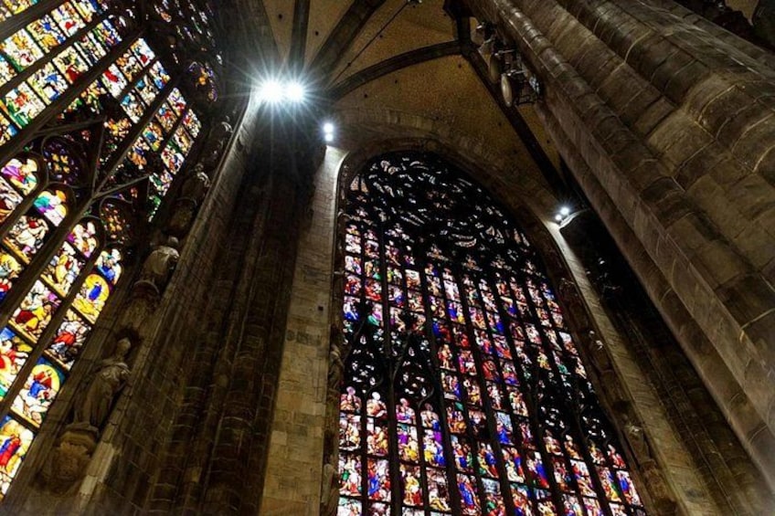 A cathedral interior with stained glass windows and stone architecture. 3
