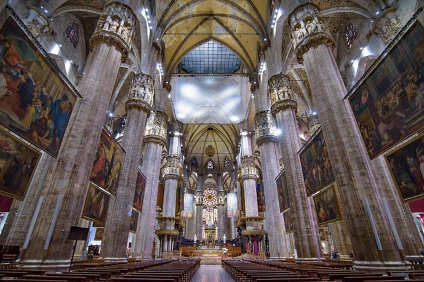 An interior of a grand cathedral with high vaulted ceilings, large columns, and detailed frescoes. 2