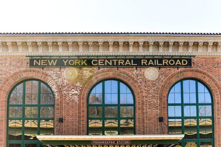 A brick building with arched windows and a sign that reads 'NEW YORK CENTRAL RAILROAD.' 2
