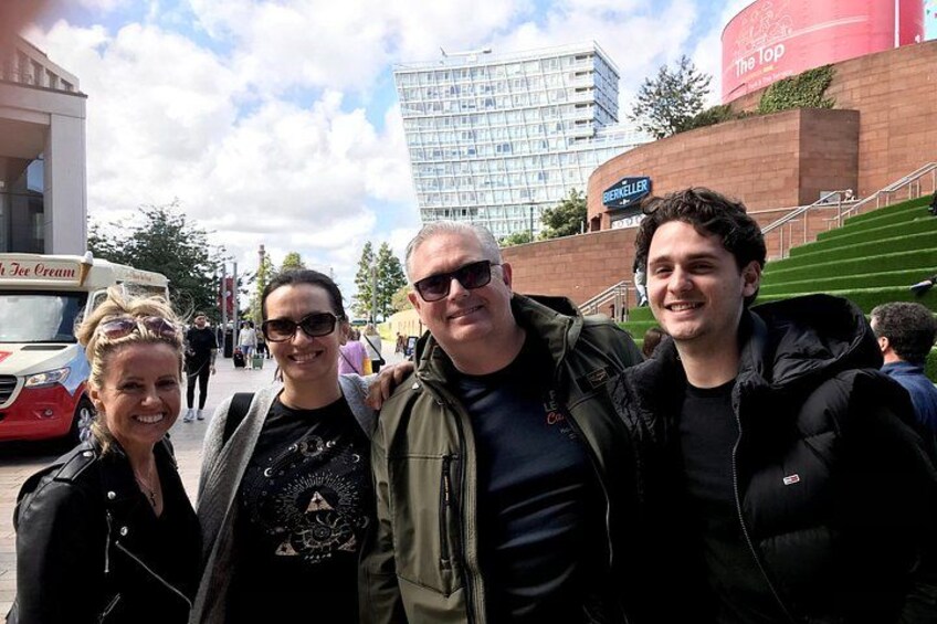 Un grupo de personas de pie en una calle, con un edificio y un cartel que dice 'The Top' al fondo. 5