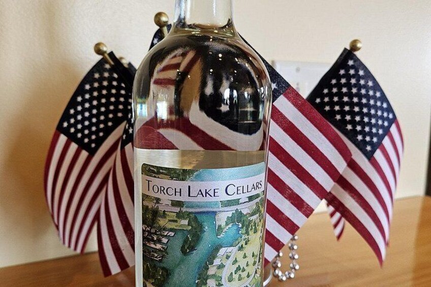 A bottle of Torch Lake Cellars wine with American flags in the background. 3