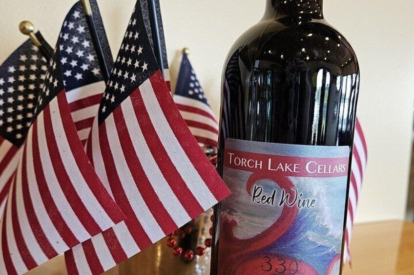 A bottle of Torch Lake Cellars Red Wine with a label featuring a red and white flag design. 4