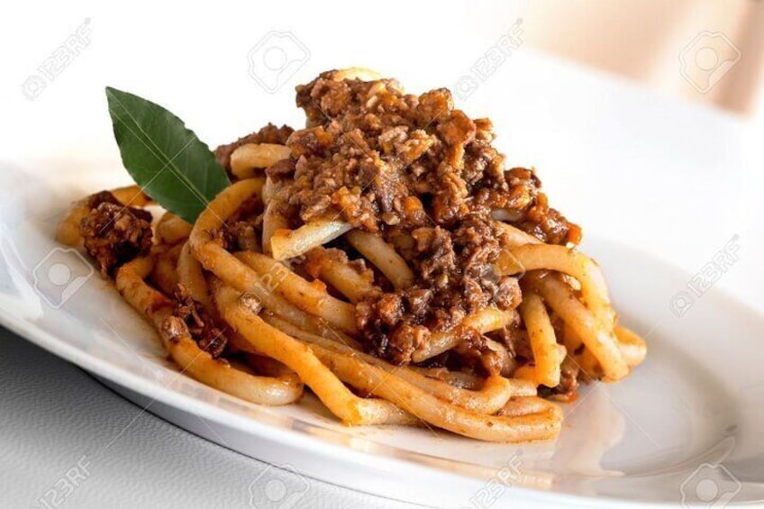 En tallerken spaghetti med hakket kød og et laurbærblad som pynt. 2