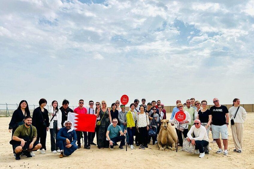 En gruppe mennesker på en sandstrand under en overskyet himmel. 5