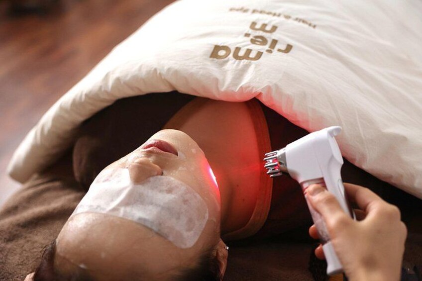 A person lying down with a pillow and a device being used on their head. 5