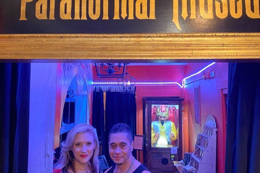 Una entrada iluminada con neón y un cartel que dice 'Paranormal Photo'. 4