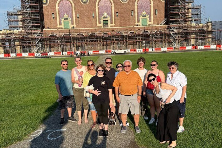 A group of people posing in front of a building with scaffolding. 2