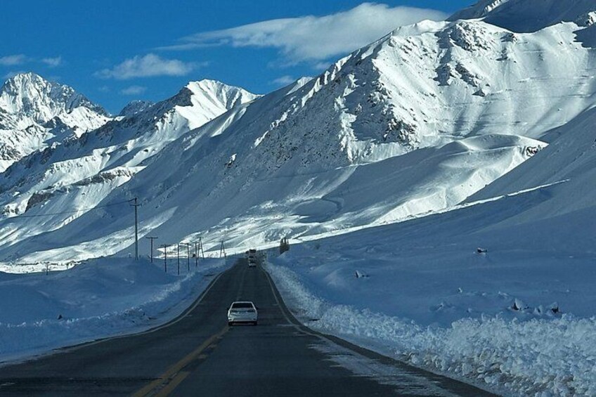 A snow-covered mountain road with a vehicle. 3