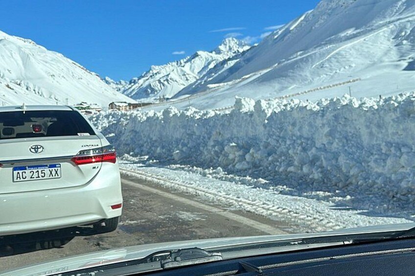 A white Toyota SUV on a snow-covered road with mountains in the background. 4