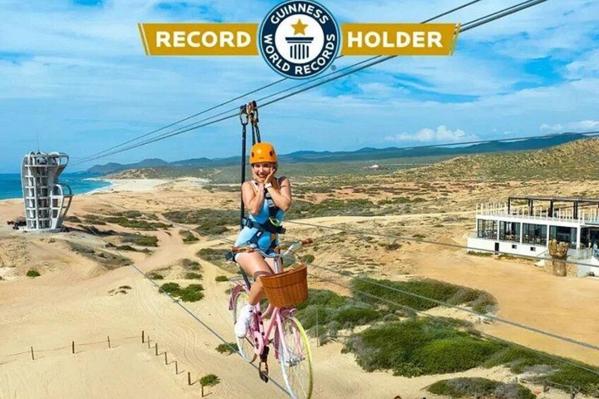 Una persona fa zip-line sopra un paesaggio desertico, con una funivia sullo sfondo. 3