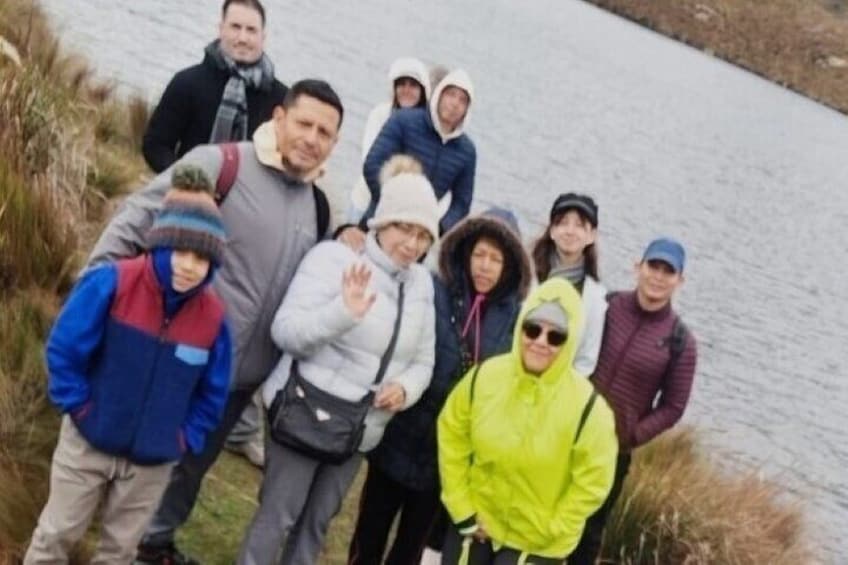 Un grupo de personas de pie junto a un camino cerca del agua. 1