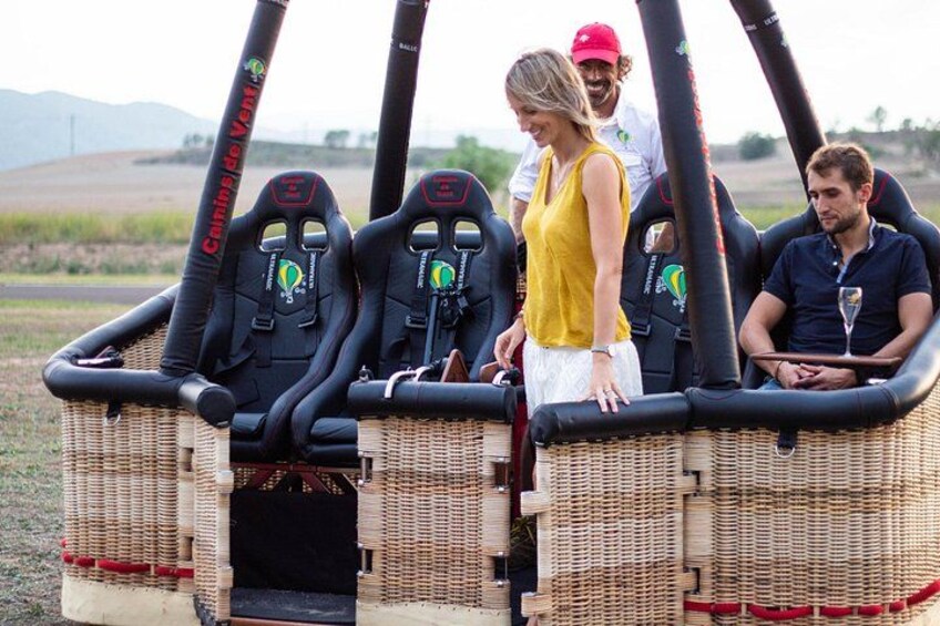 A wicker vehicle with black seats and a steering wheel, parked outdoors. 2