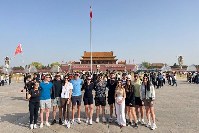 A group of people posing in front of a historic building with traditional architecture. 1
