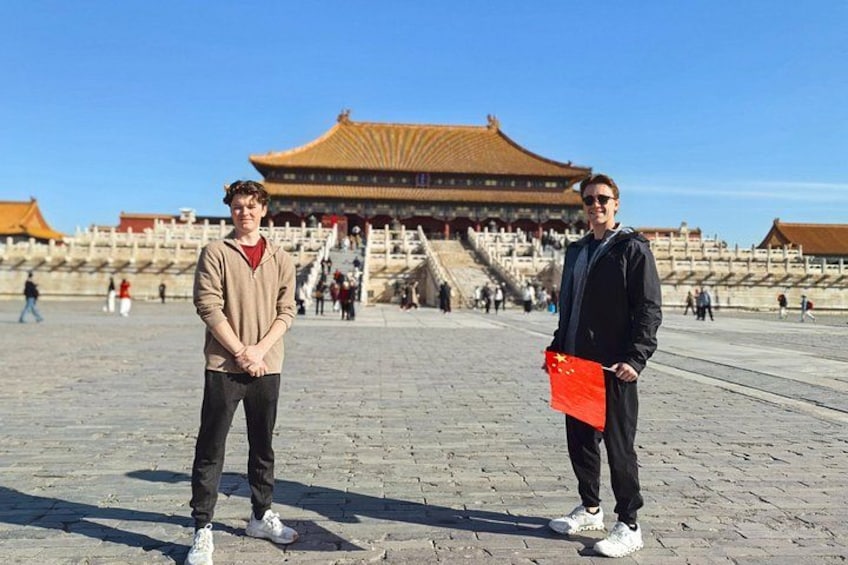 Two people standing in front of a traditional Chinese building with a large, ornate roof. 2