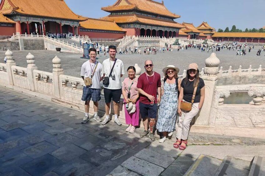 A group of people standing in front of a large, historic building with traditional architecture. 3