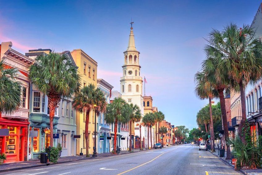 A street lined with palm trees and historic buildings, leading to a prominent clock tower. 3
