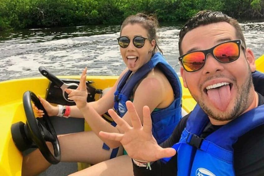 Two people in a yellow raft on a river surrounded by greenery. 4