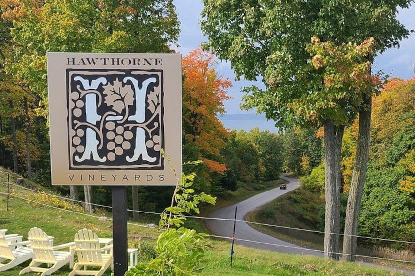 A sign for Hawthorne Vineyards with a scenic road view. 5