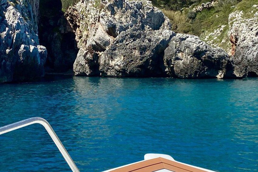 Un bateau près de falaises rocheuses, sur une eau d’un bleu limpide. 1