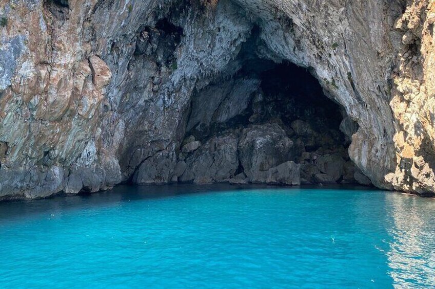 Une formation rocheuse naturelle dotée d’une entrée de grotte et d’une eau d’un bleu cristallin. 4