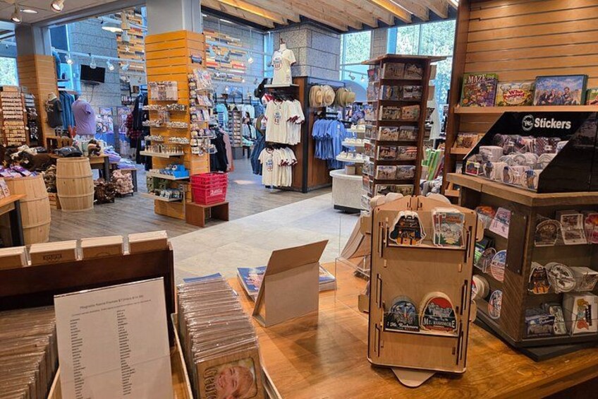 A retail store with wooden shelves, a counter, and various merchandise including clothing and accessories. 3