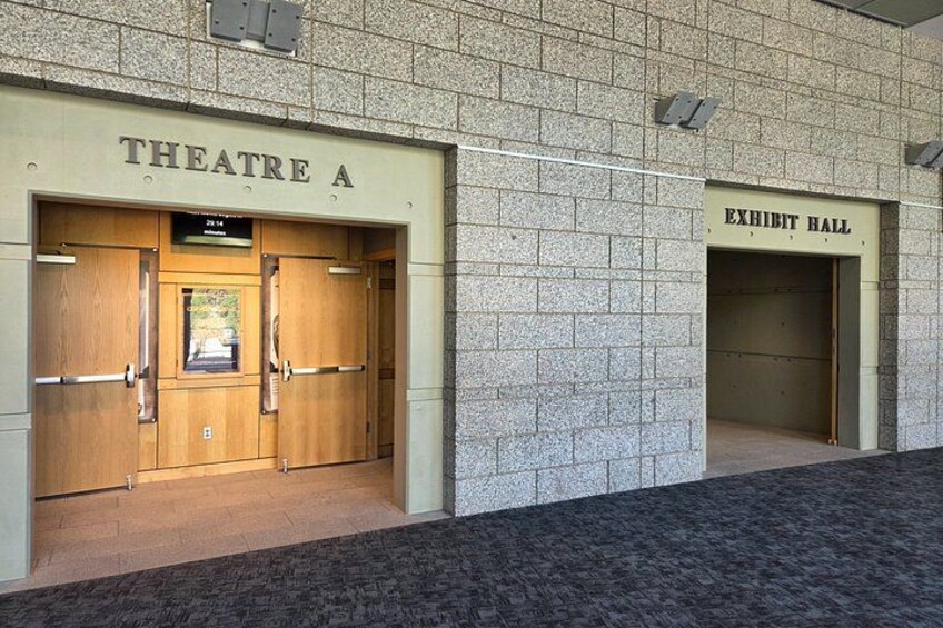 Theatre A and an Exhibit Hall entrance with wooden doors and a tiled wall. 5
