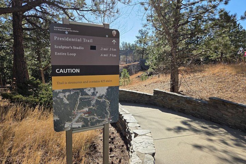 A trail sign with directions to the Presidential Trail, Sculptor's Studio, and the entire loop. 2