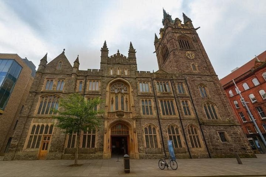 A historic building with a clock tower, arched windows, and a central entrance. 5