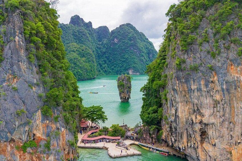 A karst landscape with a water body, limestone cliffs, and a small settlement with buildings. 4