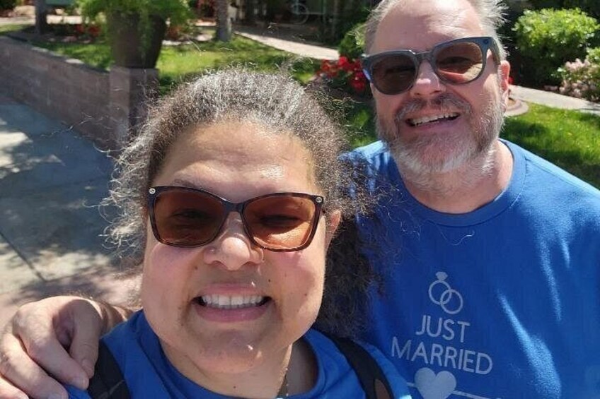 Two people wearing blue shirts with a wedding ring symbol and the text 'JUST MARRIED'. 2