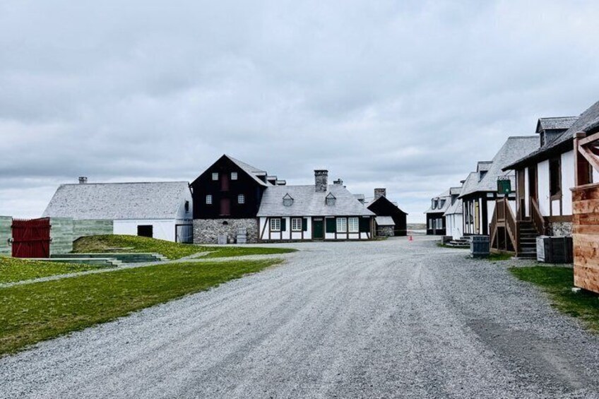 A gravel road leading to a farm with a large barn and several smaller buildings. 2