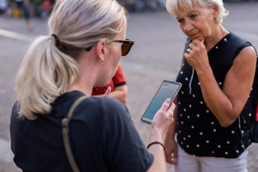 Two people conversing, one holding a smartphone. 3
