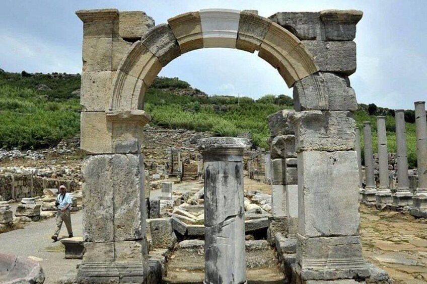 Ancient stone ruins with columns and an archway. 4