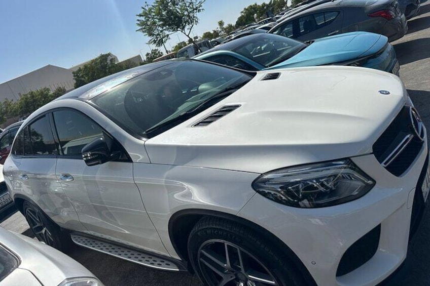 A white car parked in a lot with other vehicles. 4