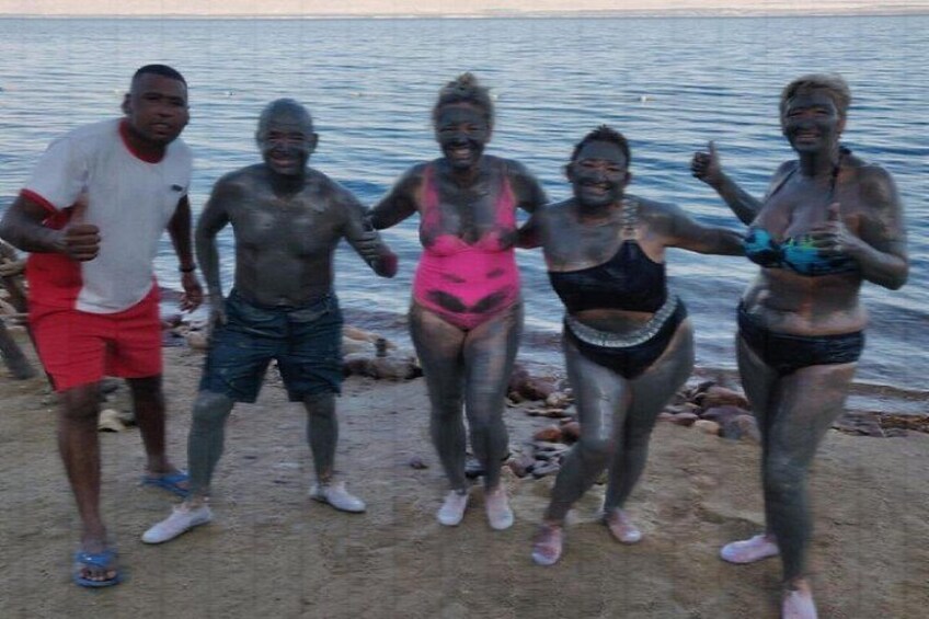 A group of people standing on a beach near water. 4