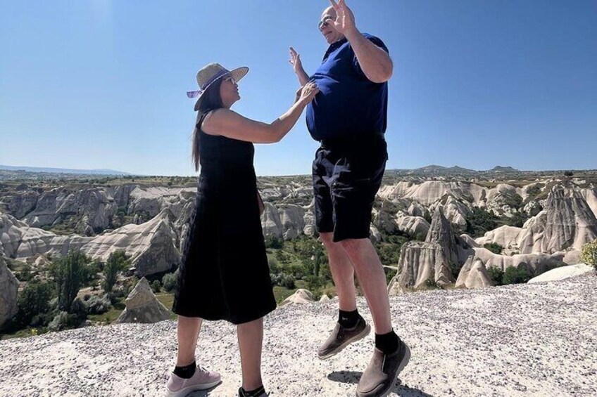 Un couple saute dans un paysage rocheux, parsemé de formations géologiques uniques. 2
