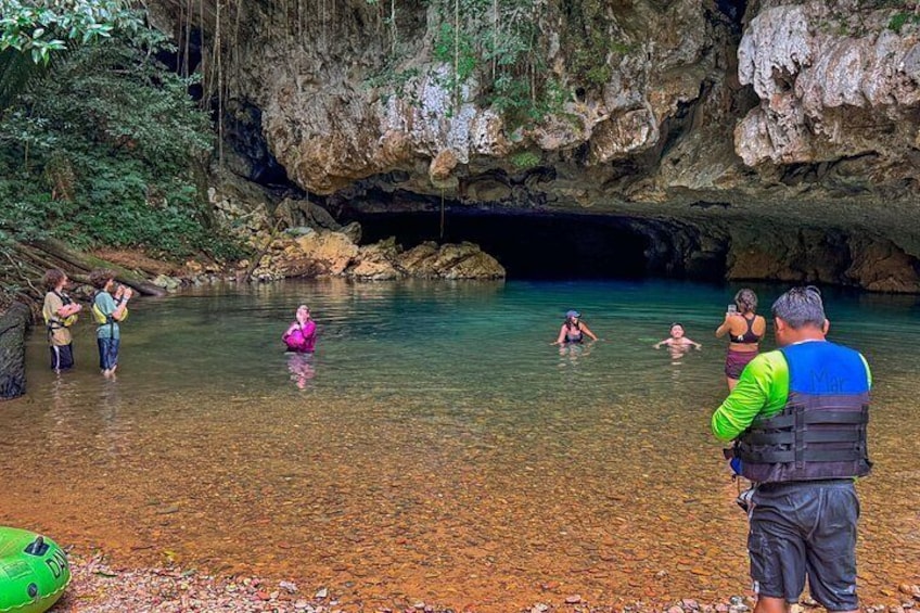A group of people in a natural water body surrounded by rocky cliffs. 4